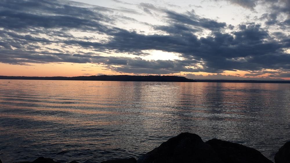 Montanha com vista para o mar calmo sob o céu cinzento