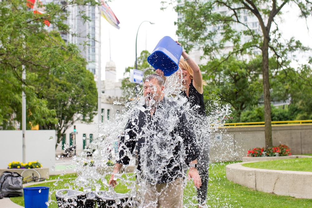 person pouring water to man