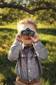 Kids exploring nature with magnifying glasses in a sunny park nearby Calgary.