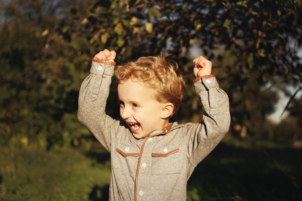 a little boy that is standing in the grass