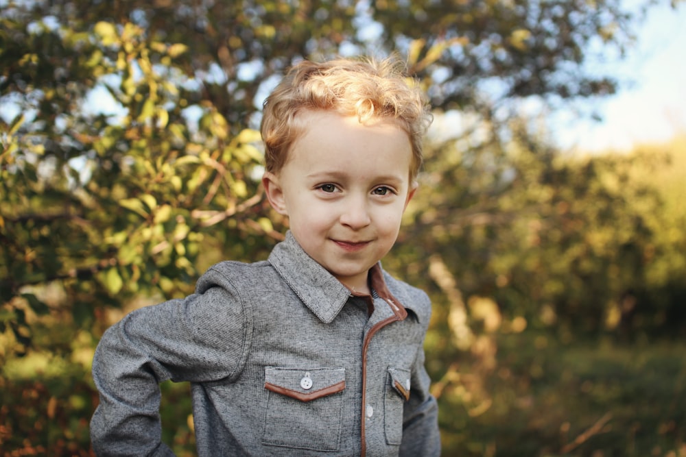 boy standing near tree at daytime