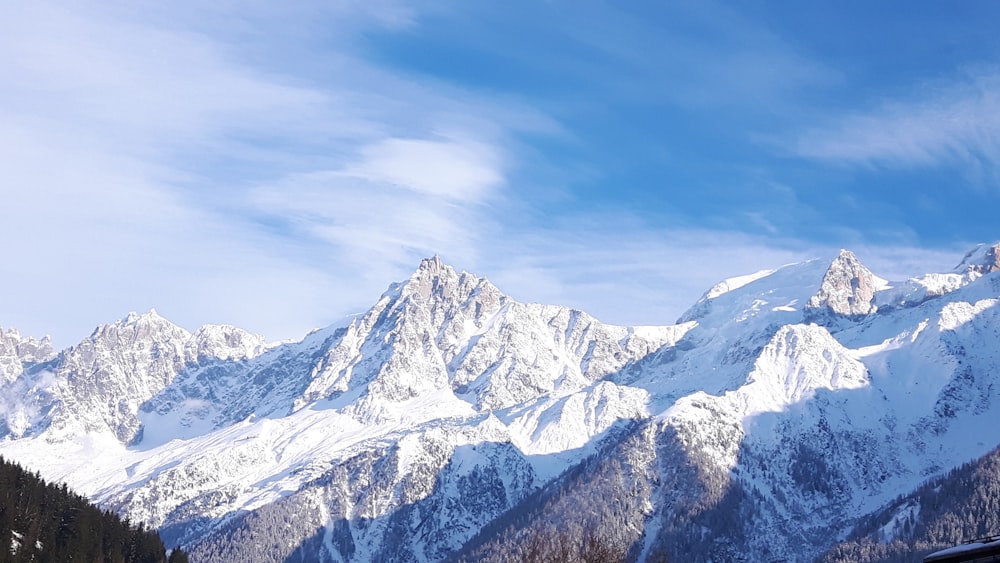 a snow covered mountain range with a blue sky in the background
