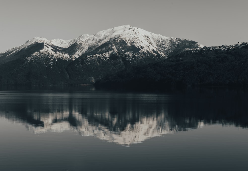 Tagsüber schneebedeckter Berg in der Nähe eines Gewässers