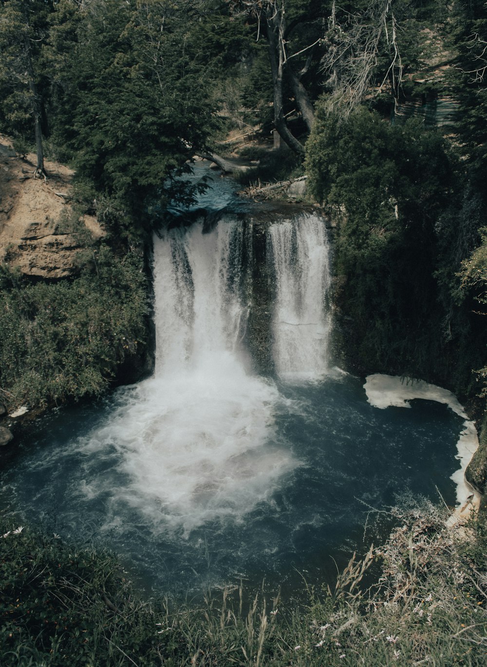 waterfall between trees at daytime