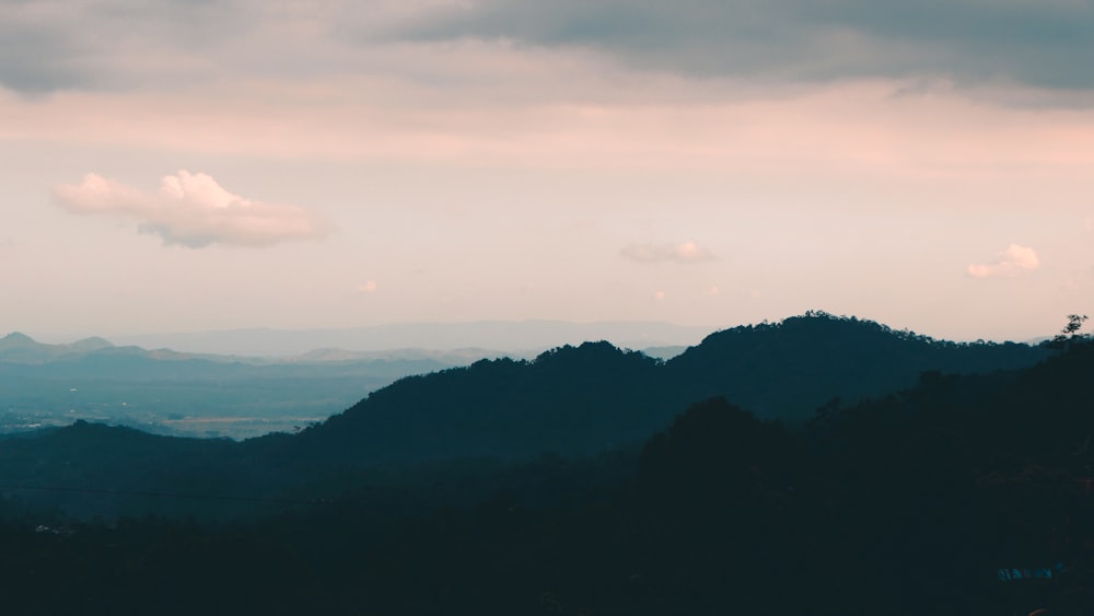 a view of a mountain range with clouds in the sky