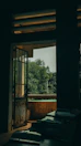 View of the room’s balcony overlooking a quiet courtyard with greenery.