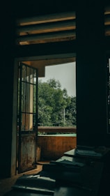 A private balcony overlooking dense forest with comfortable seating and warm lighting.