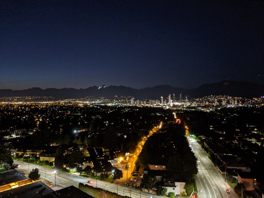 une vue d’une ville la nuit depuis le sommet d’une colline