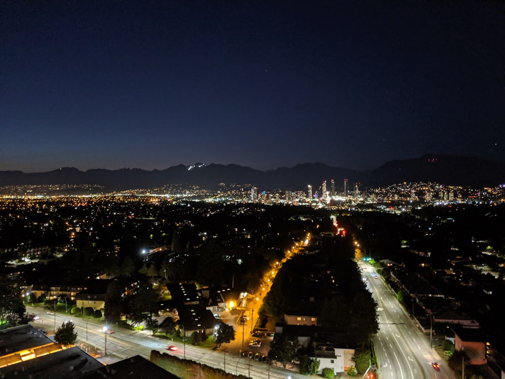 a view of a city at night from the top of a hill