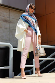 A model wearing a modern, stylish pashmina scarf in a bright outdoor setting.