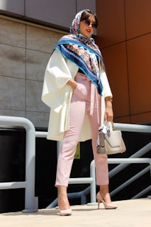 woman wearing pink pants holding grey leather handbag