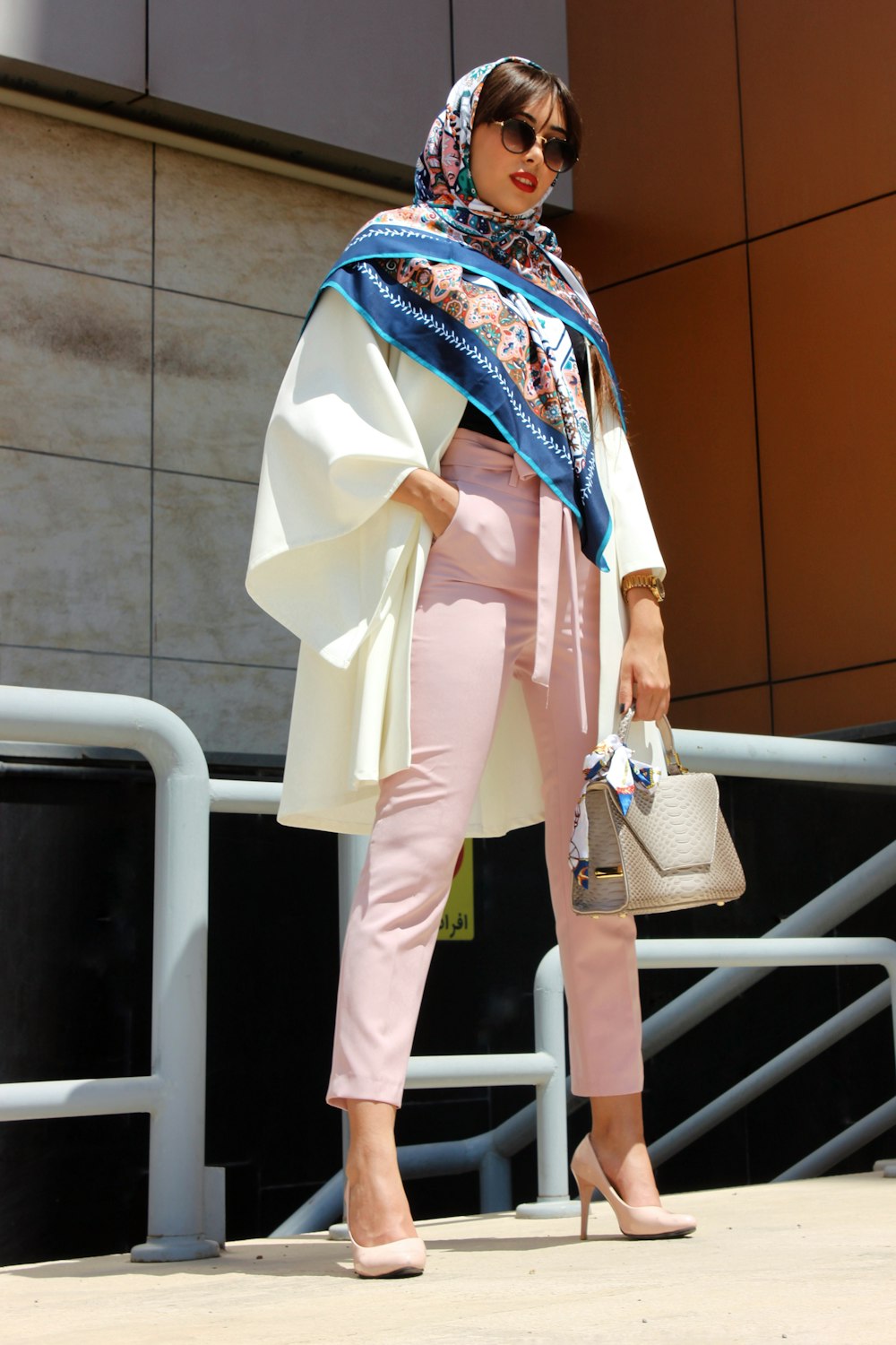 woman wearing pink pants holding grey leather handbag