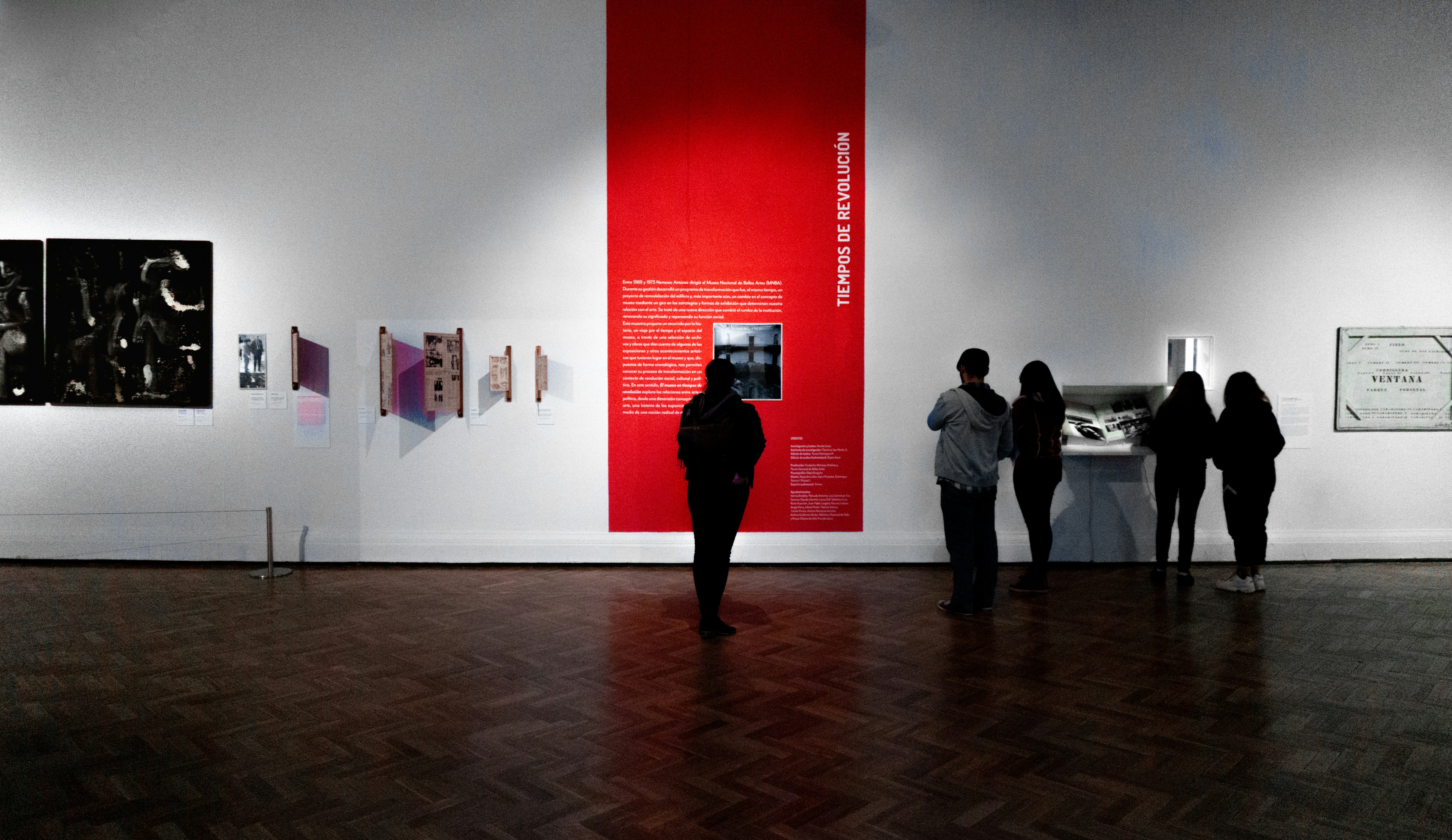 People reading exhibit labels in a museum
