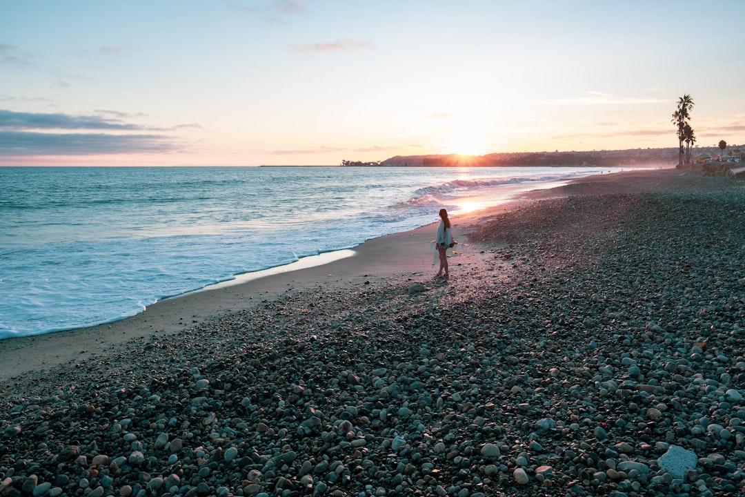 woman standing on shoreline near body of water