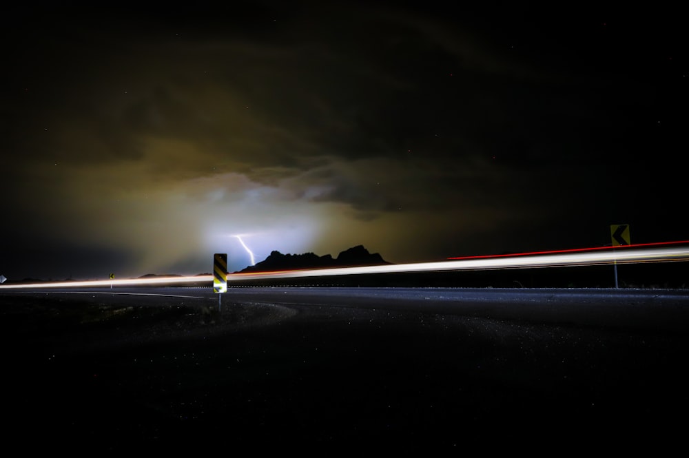 a long exposure photo of a road at night