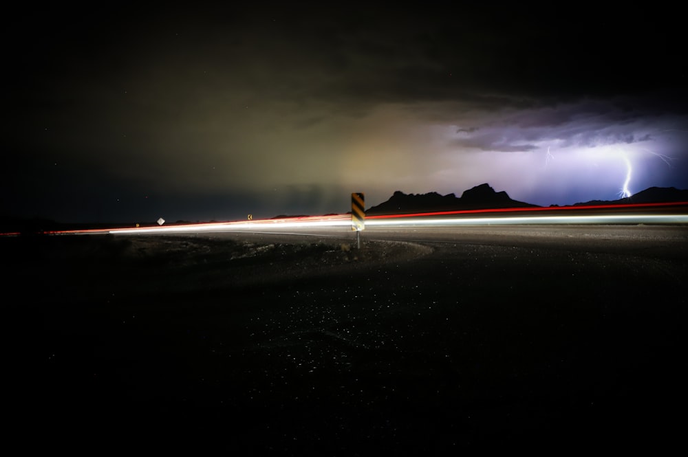 a lightning bolt is seen in the sky over a road