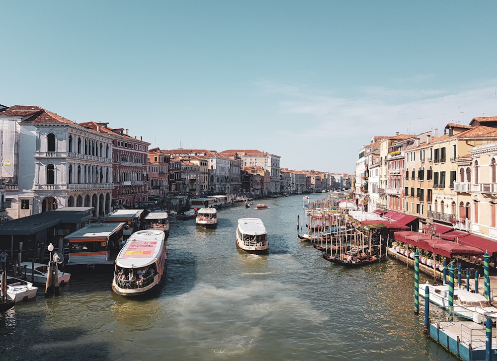 boats on body of water near buildings during day