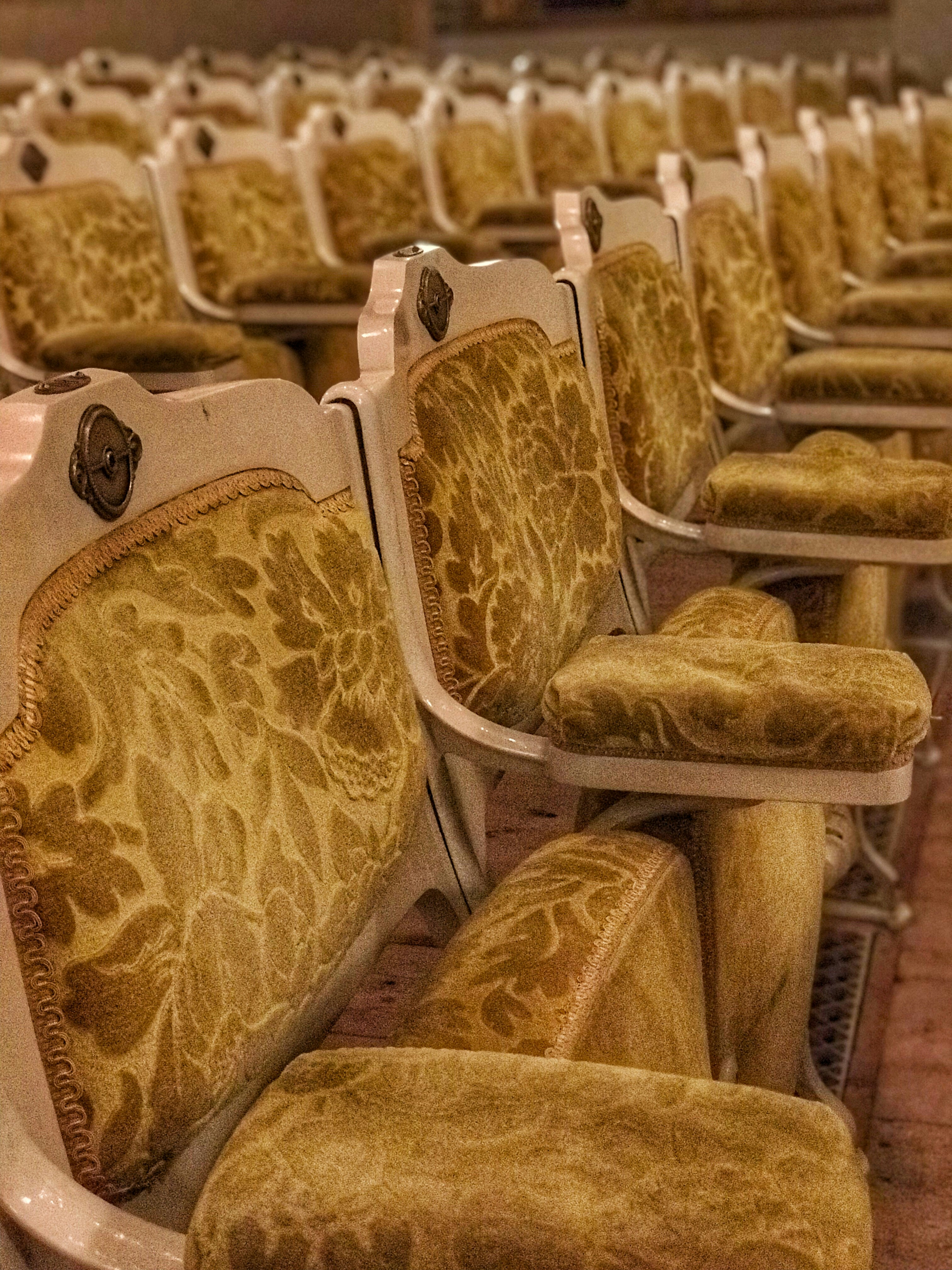 Warm golden cinema screen with glowing amber light, dark intimate theatre atmosphere, romantic dim lighting, empty seats waiting