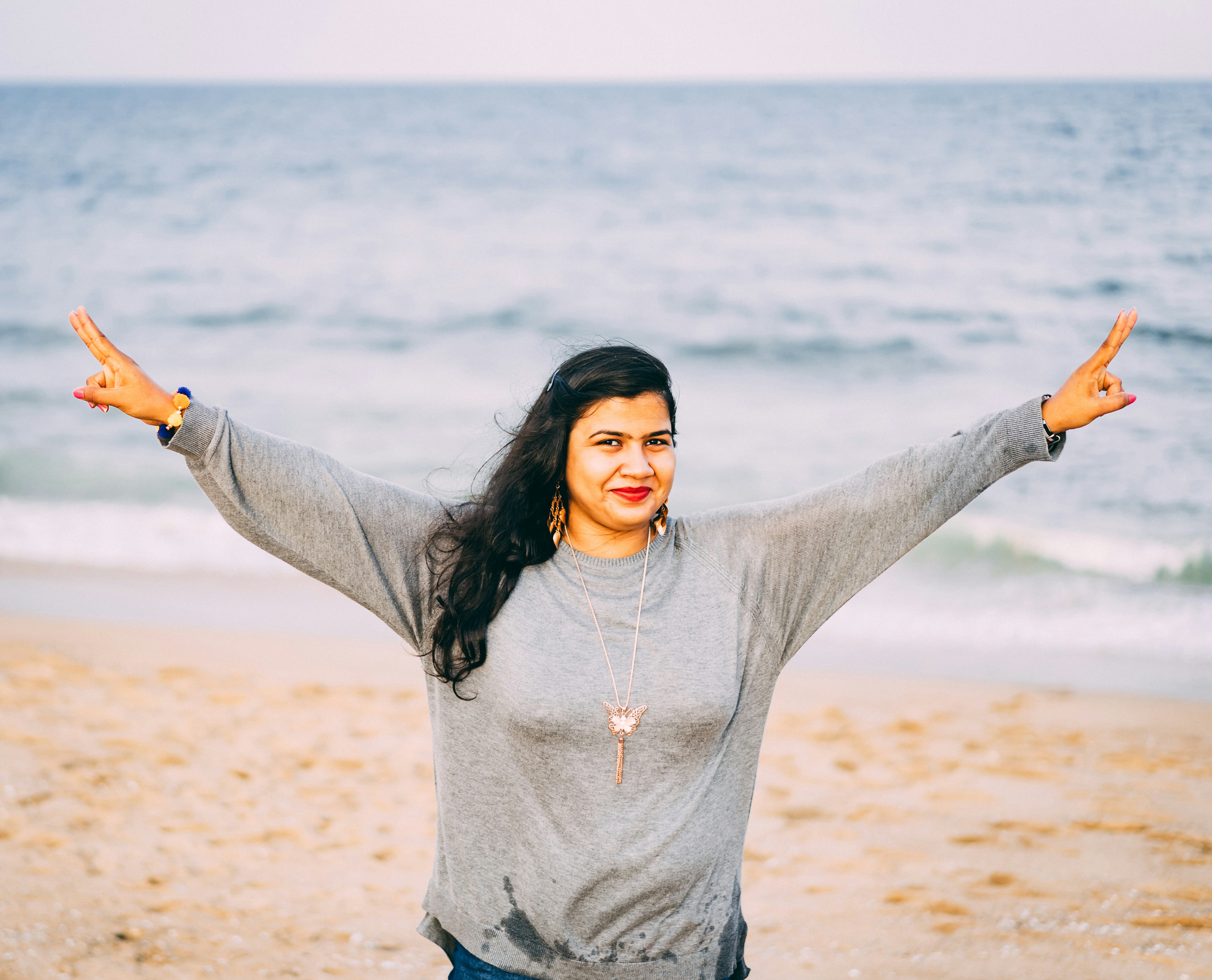 woman standing and spreading her arms on seashore