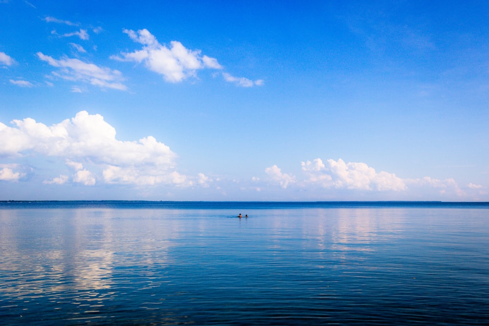 Specchio d'acqua sotto il cielo blu e bianco durante il giorno