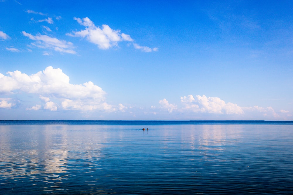 corpo de água sob o céu azul e branco durante o dia