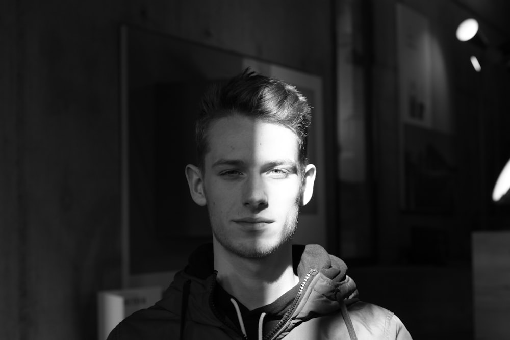 grayscale photography of man wearing jacket