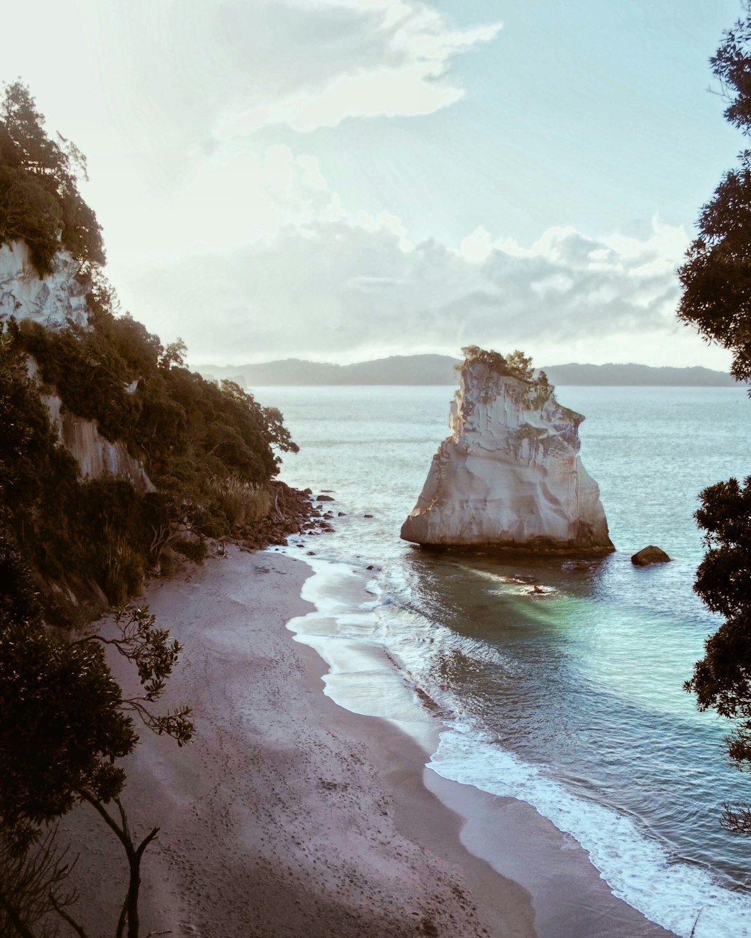 white rock formation beside body of water at daytime