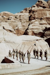 A detailed scene of Roman legionnaires preparing their camp under a fiery sunset, with banners waving and soldiers sharpening weapons.