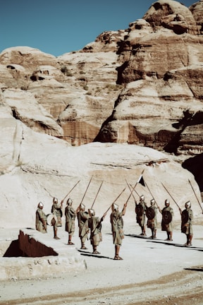 A vivid reenactment scene showing ancient soldiers clashing with spears and shields under a stormy sky.