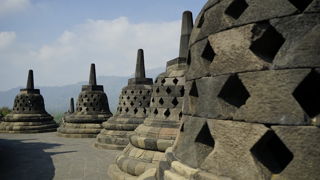 Rows of stone bell-shaped stupas on the upper terraces of Borobudur Temple