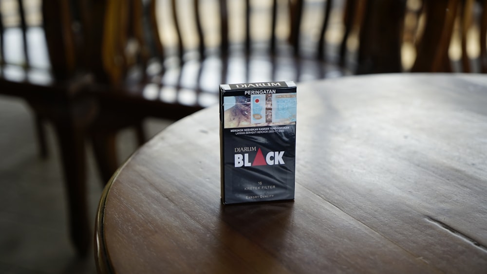 Schwarze Zigarettenschachtel auf braunem Holztisch