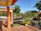 A cozy terrace with freshly cleaned tiles and potted plants, bathed in warm sunlight.