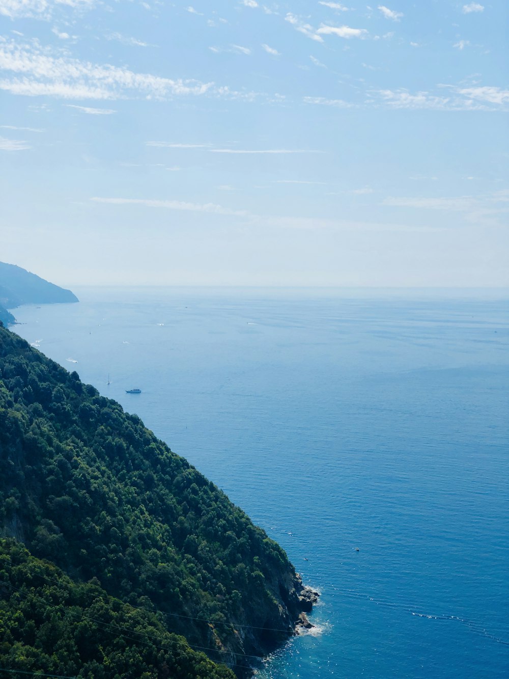 calm body of water near mountain during daytime