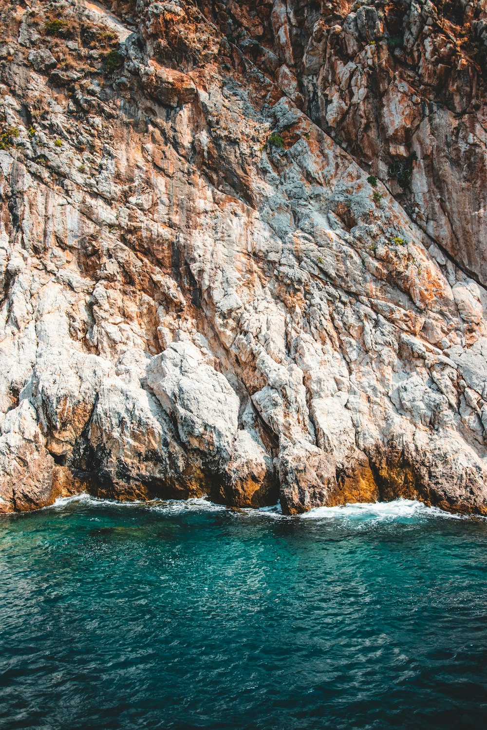 calm body of water near mountain during daytime