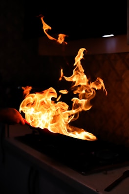 Flames dancing from a sauté pan in the kitchen.