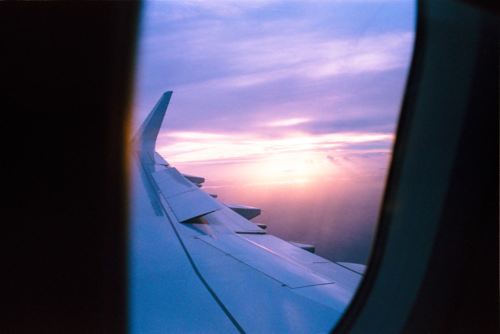 L'ala di un aeroplano mentre il sole tramonta
