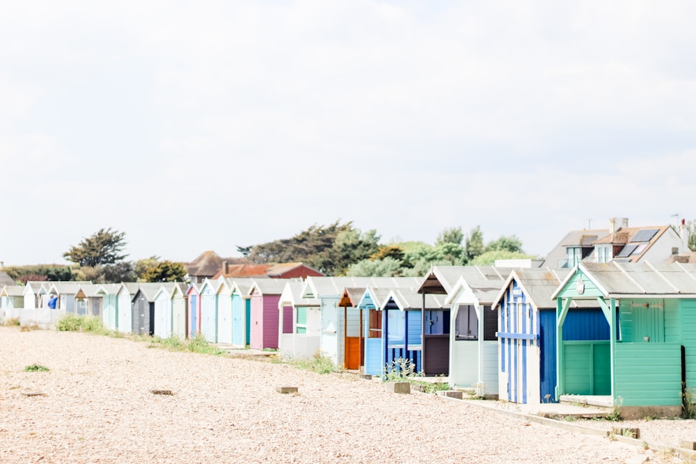 a row of colorful beach huts sitting on top of a sandy beach