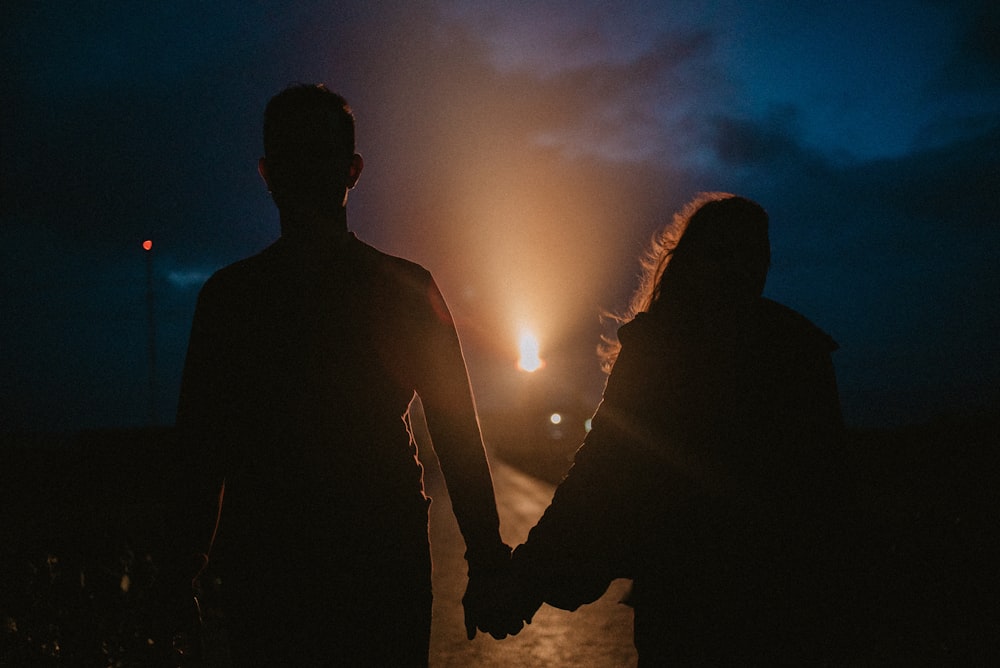 gray-scale photo of man and woman holding hands