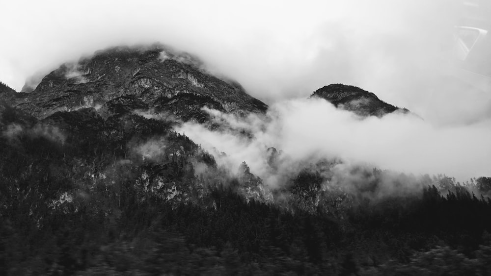 gray-scale photo of mountain and sea of clouds