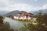 A vibrant photo of Bhutan's iconic Tiger's Nest Monastery perched on a cliffside surrounded by lush greenery
