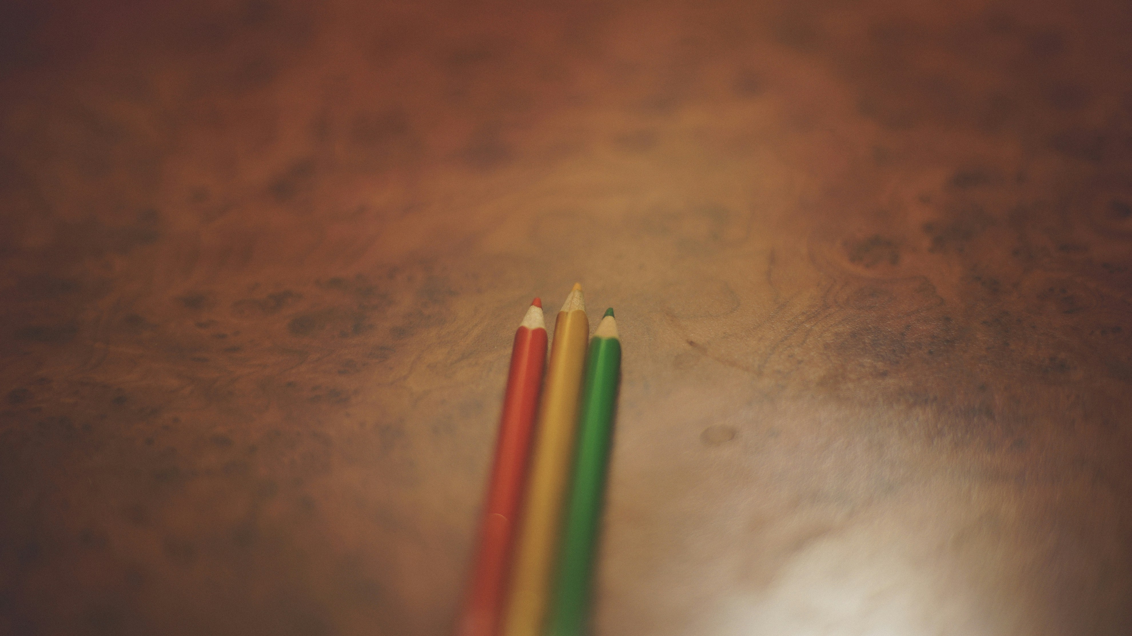 red, yellow, and green pencils on brown surface