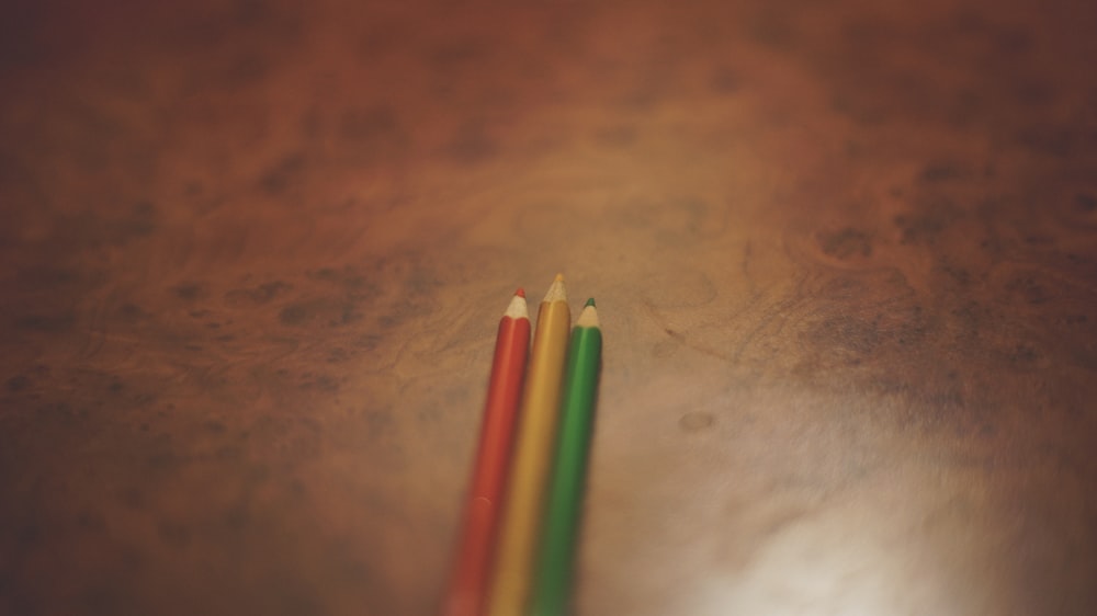 red, yellow, and green pencils on brown surface