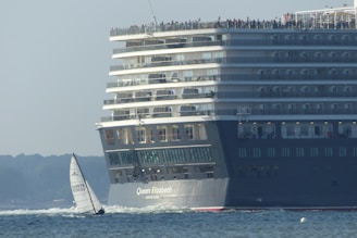 sailing boat beside cruise ship during daytime