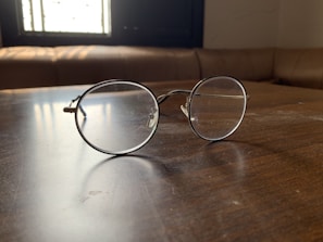 Stylish sunglasses resting on a wooden table with soft natural light.