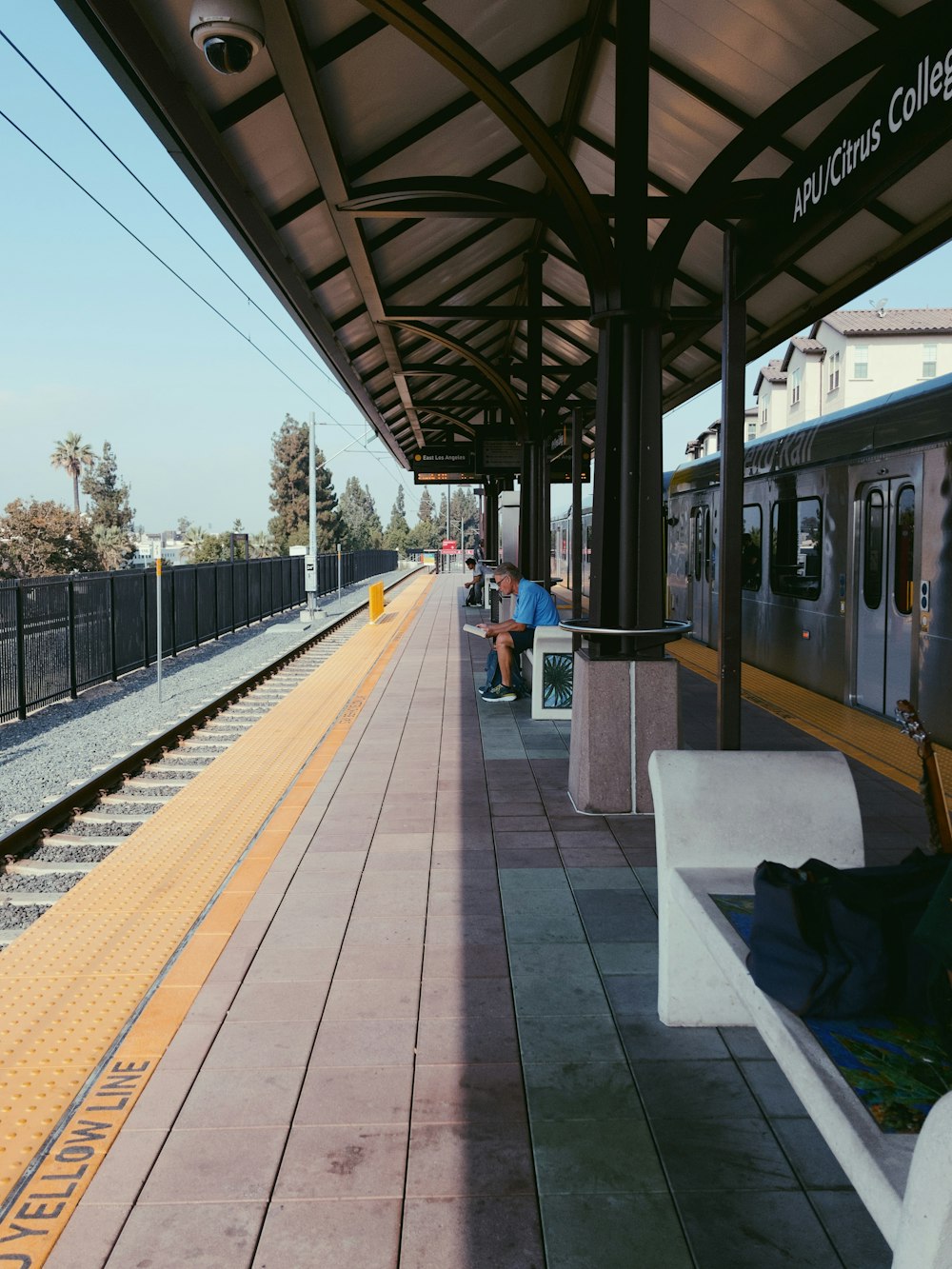 white and gray train beside black and gray waiting shed