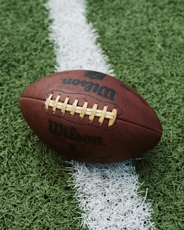 Close-up of a football player gripping the ball tightly, ready to make a play.