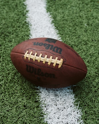 A close-up of a quarterback throwing a football during an intense NFL game.