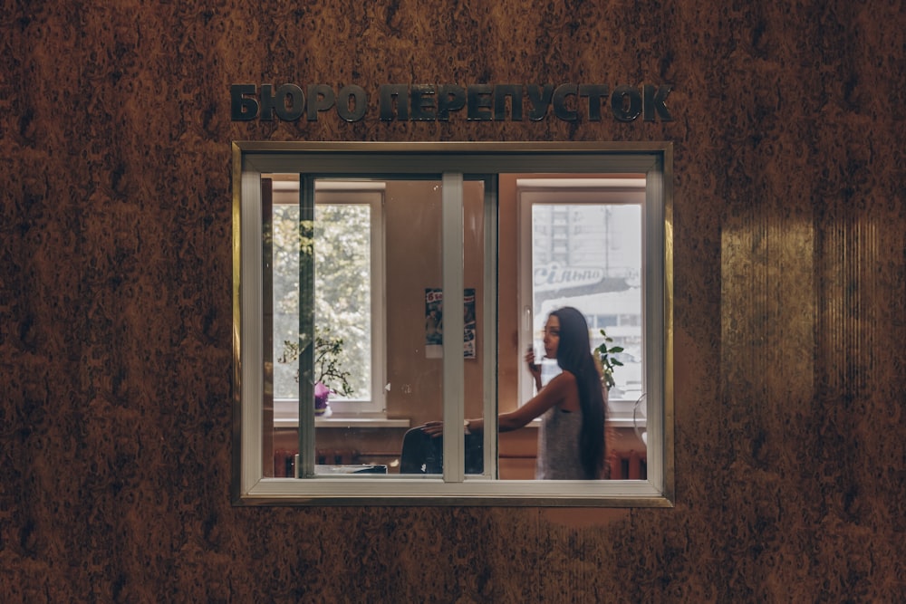 a woman looking out a window in a building