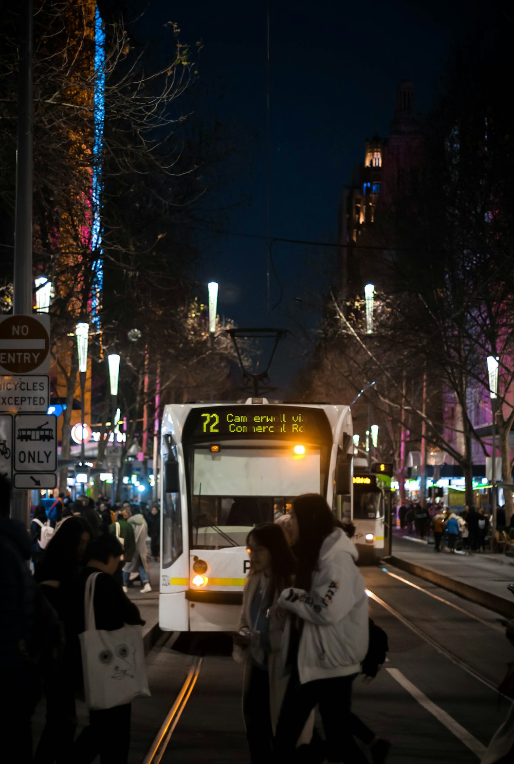 a city bus driving down a street at night