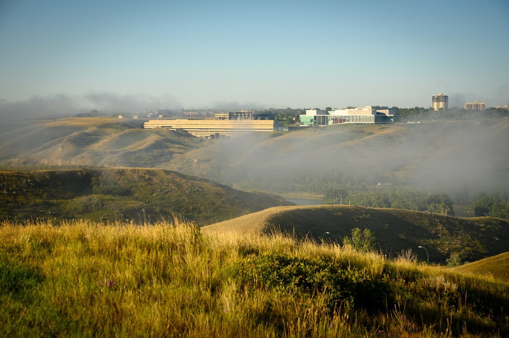 a foggy landscape with a building in the distance